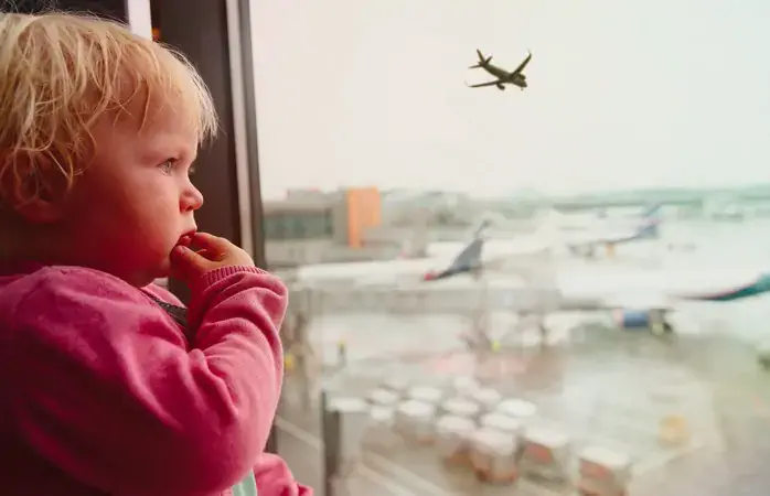 family travel concept- baby look at planes in airport