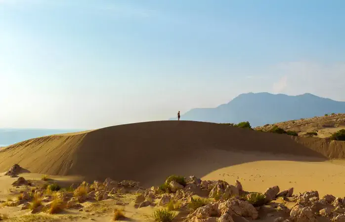 Man standing on sand dune looking over Patara beach.