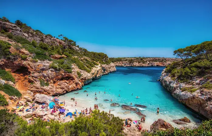 A small, sandy beach with shallow turquoise waters.