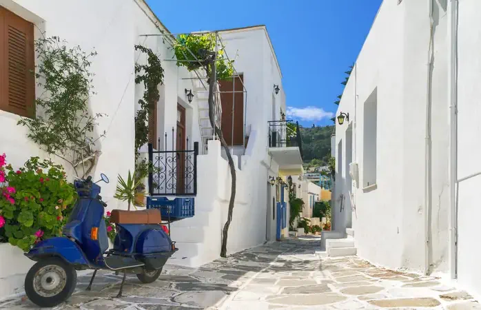 Classical narrow street with a painted sidewalk in Parikia